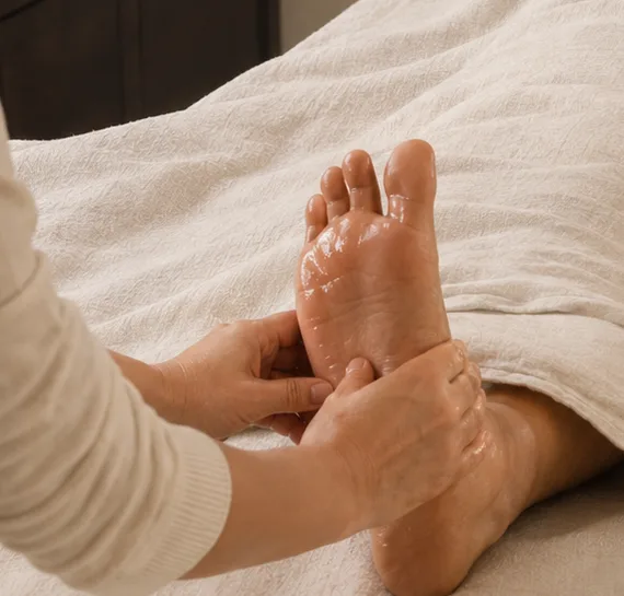 Hands-on Pada Abhyanga foot massage during a Shrii Aesthetics facial ritual
